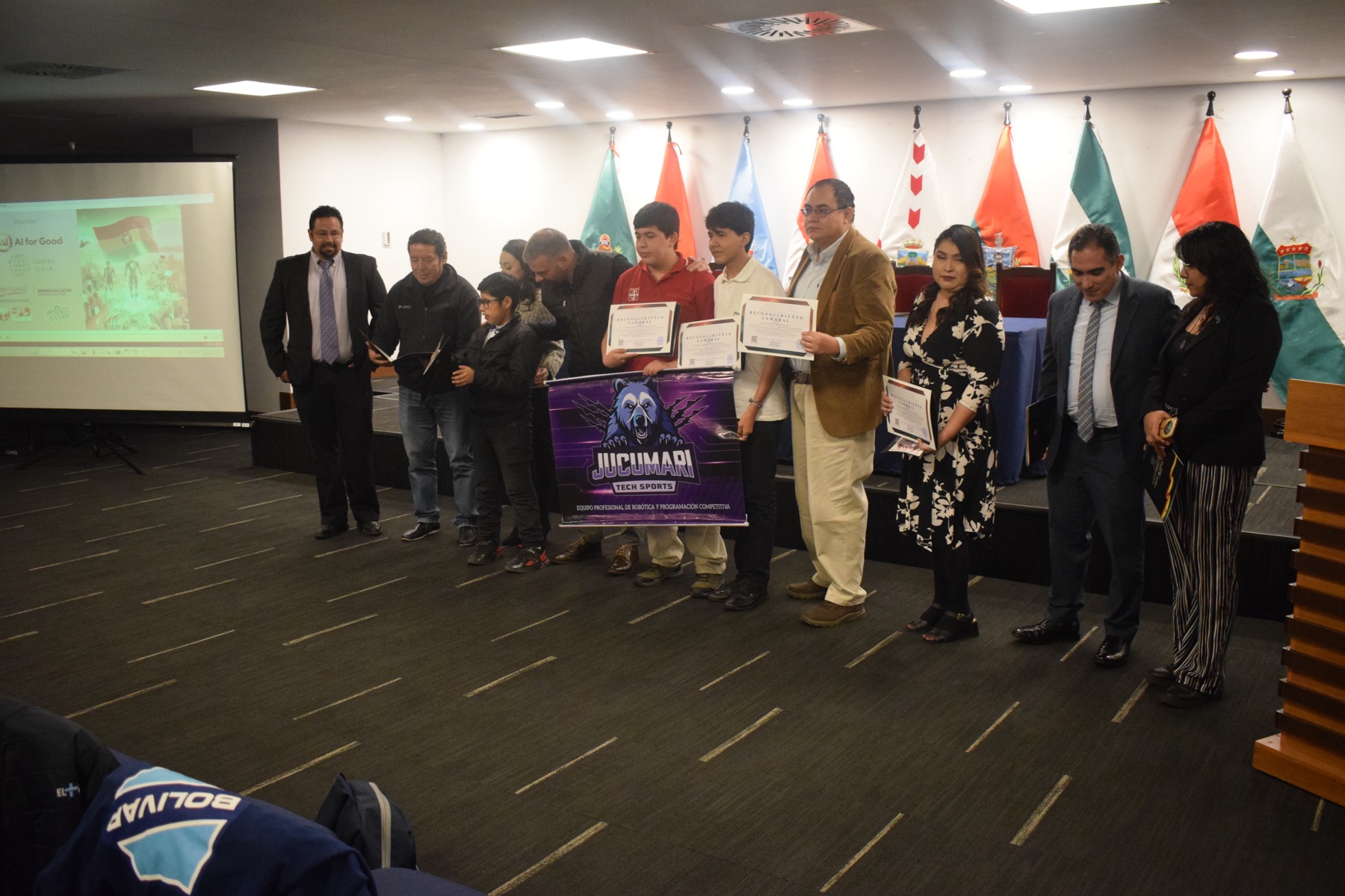 Equipo Jucumari Tech Sports con sus certificados y estandarte